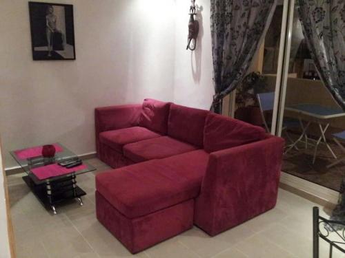 a living room with a red couch and a table at Modern Apartment in Casablanca, Terrace and City View in Casablanca