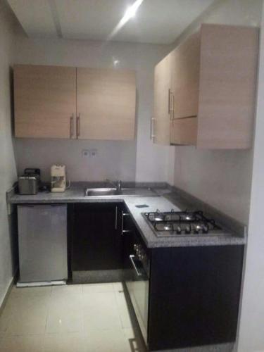 a small kitchen with a stove and a sink at Modern Apartment in Casablanca, Terrace and City View in Casablanca