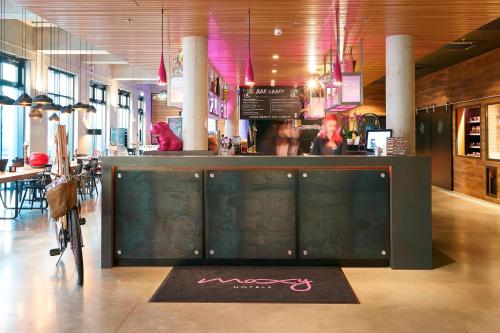 ein Restaurant mit einer Bar in der Mitte eines Zimmers in der Unterkunft Moxy Frankfurt Eschborn in Eschborn