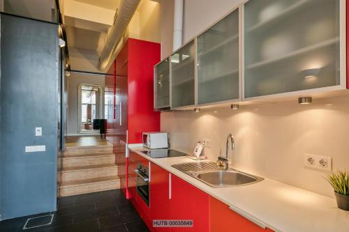 a kitchen with a sink and a red wall at Alcam Les Corts in Barcelona