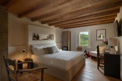 a bedroom with a large white bed and a window at Corte Massimago in Mezzane di Sotto