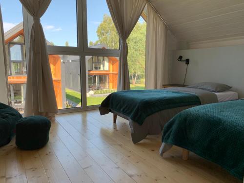 a bedroom with two beds and a large window at Baltic Homes Lubiatowo in Lubiatowo