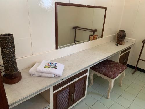 uma casa de banho com um balcão com um espelho e um banco em Casa Don Julian Guesthouse em Bais