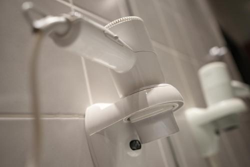 a white toilet in a bathroom with a shower at Hotel Attaché an der Messe in Frankfurt/Main
