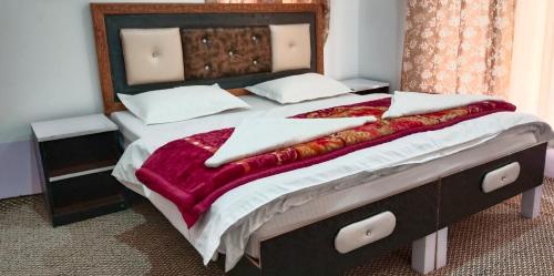 ein Schlafzimmer mit einem großen Bett mit einer roten Decke in der Unterkunft Sukoon Turtuk Home Stay in Turtok