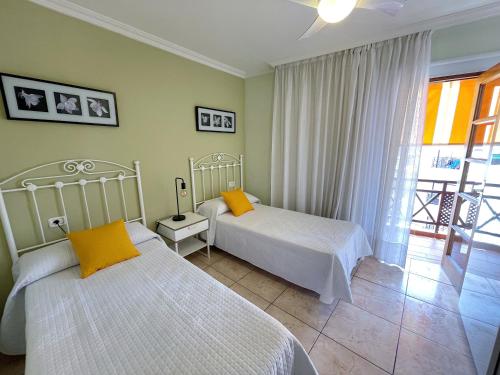 a bedroom with two beds and a balcony at Edificio Don Antonio in Los Cristianos