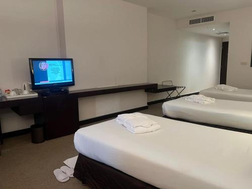 a hotel room with two beds and a flat screen tv at Al Jazira Club Hotel in Abu Dhabi
