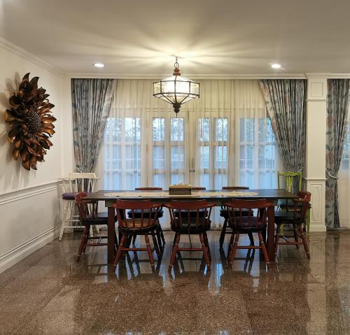 a dining room with a table and chairs at Chiangmai Singharat Road Villa in Chiang Mai