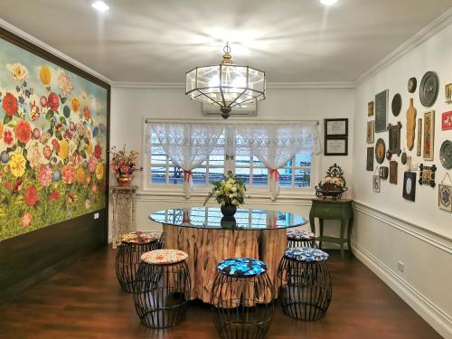 a dining room with a table and stools at Chiangmai Singharat Road Villa in Chiang Mai