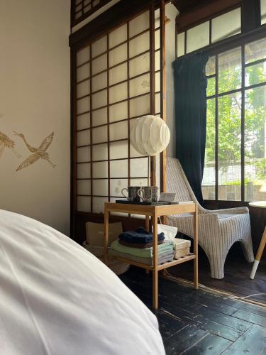 a bedroom with a bed and a table with a lamp at Villa Sacra in Kamakura