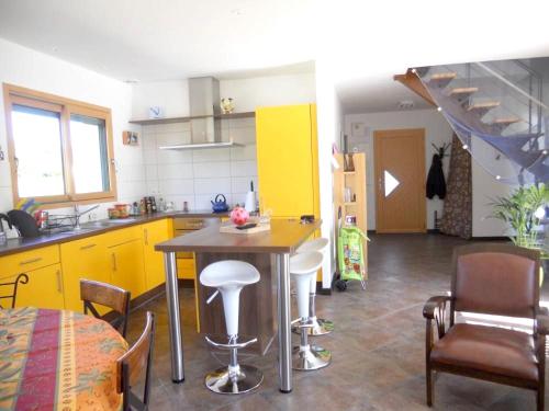 パンマールにあるMaison de 3 chambres a Penmarch a 500 m de la plage avec jardin clos et wifiのキッチン(黄色のキャビネット、テーブル、椅子付)