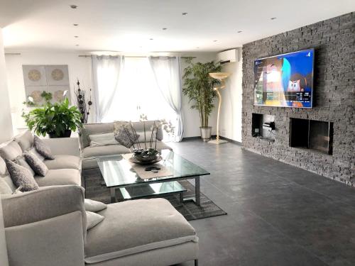 a living room with a couch and a tv on a brick wall at Villa pittoresque à Mougins avec piscine privée. in Mougins