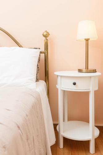 a white bedside table with a lamp on it at Villa Armeni by CorfuEscapes in Corfu