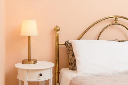 a bedroom with a bed and a lamp on a side table at Villa Armeni by CorfuEscapes in Corfu