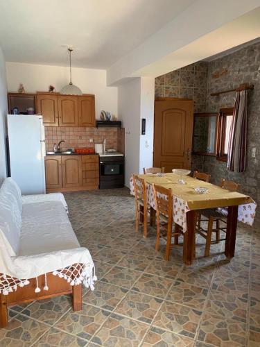 a kitchen with a table and chairs in a room at Mani Castle Houses in Mína