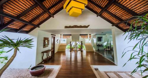a living room with wooden ceilings and a hallway with plants at Navutu Dreams Resort & Wellness Retreat in Siem Reap
