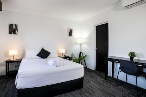a hotel room with a bed and a desk at Joondalup City Hotel in Perth