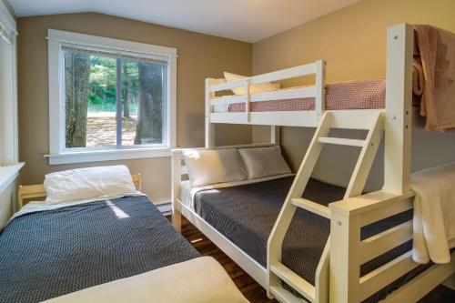 a bedroom with bunk beds and a window at Pet-Friendly Kalkaska Cottage on Lake Crawford! in Kalkaska
