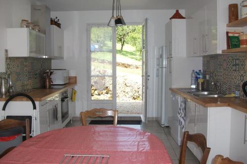 a kitchen with a table with a red table cloth at Gite les Noyers in Noailhac