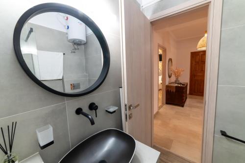 bagno con lavandino nero e specchio di Villa Maria Tsovili a Párga