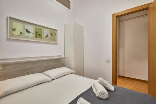 バルセロナにあるBBarcelona Sagrada Familia Terrace Flatのベッドルーム1室(白いベッド1台、タオル付)