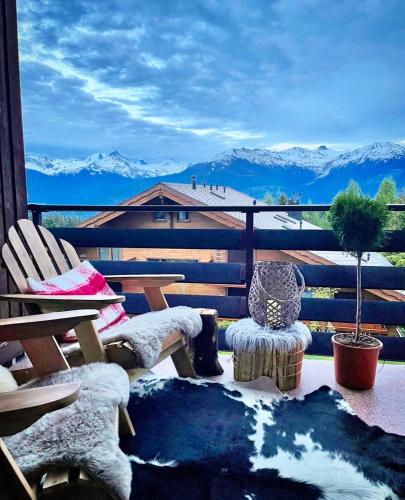 a balcony with chairs and a view of mountains at Window on Crans Montana, Appartement avec vue sur les Alpes in Crans-Montana