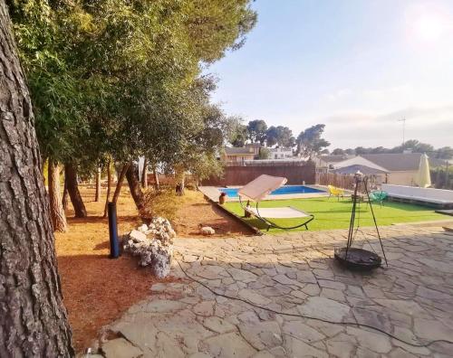 a park with a playground with a swing at Charming Villa in El Vendrell + Pool in El Vendrell