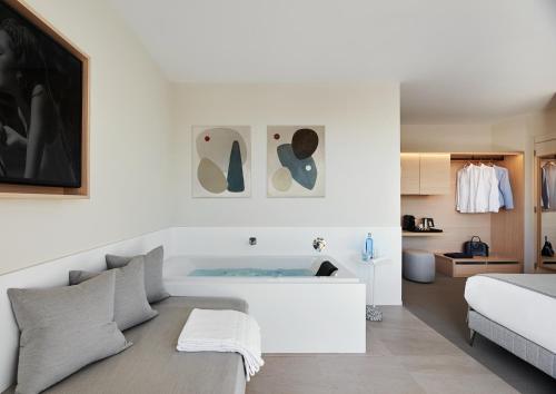 a white bedroom with a bed and a room with a bed at Hotel restaurant Ceferino in Vilanova i la Geltrú