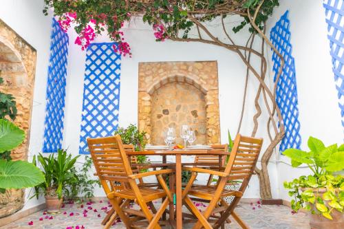 a table and chairs in a room with a fireplace at Casa Marinero - Patio Andaluz in Barbate