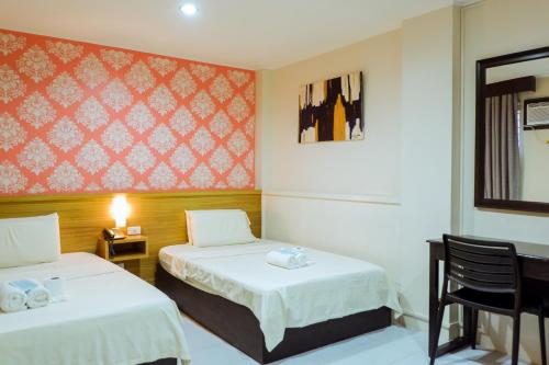 um quarto de hotel com duas camas e uma janela em Hotel Juliano em Manila