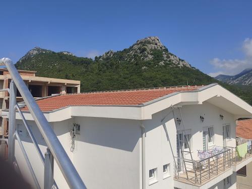 a view of a building with a mountain in the background at Studio Apartments Tea in Sutomore