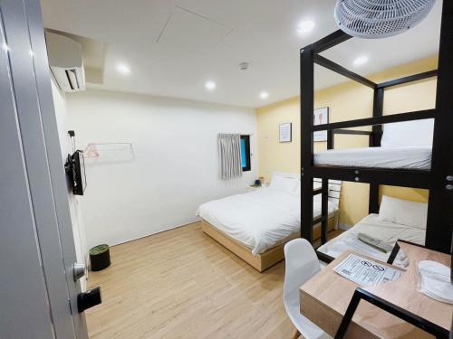 a room with two bunk beds and a table at 淡水民宿-台北Yes Hotel in Tamsui