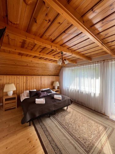 a bedroom with a bed and a wooden ceiling at Willa Popielica in Zakopane