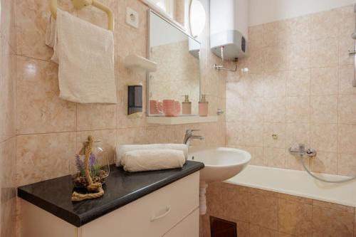 a bathroom with a sink and a toilet and a tub and a mirror at Unique Apartment in heart of the old town of Split in Split
