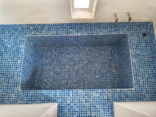 eine blau geflieste Badewanne im Bad in der Unterkunft Maison de vacance pour les amateurs de la nature in Kelibia