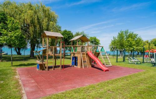 a playground with a slide in a park at Silver Side Apartments in Siófok