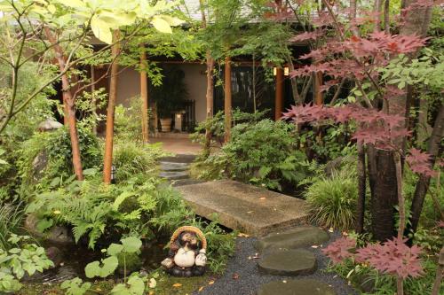 a garden with a teddy bear in the middle of a pathway at Ryoso Yufuin Yamadaya in Yufuin