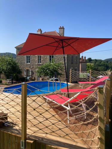 a red umbrella and some chairs and a pool at Bourgeoisie @ Brandon in Brandon