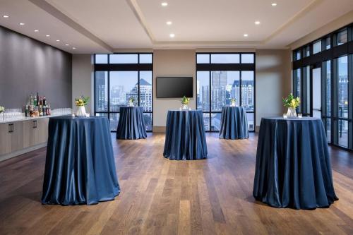 a conference room with two tables and a screen at Marriott Dallas Uptown in Dallas