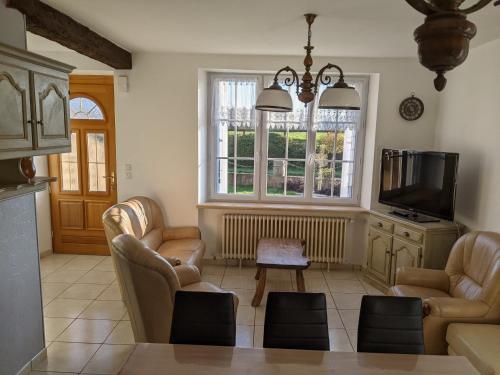 a living room with two chairs and a tv at Gites De La Melautais in Saint-Juvat