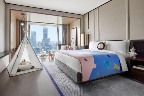 ein Schlafzimmer mit einem großen Bett und einem Spielzelt in der Unterkunft JW Marriott Marquis Hotel Shanghai Pudong in Shanghai