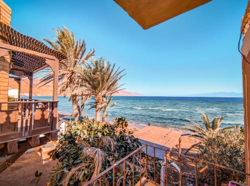 a view of the beach with palm trees and the ocean at Villa sarda Blue in Dahab