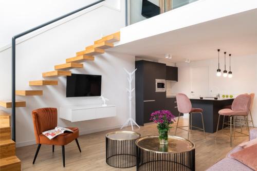 - un salon avec un escalier, une table et des chaises dans l'établissement Murillo Gardens Sevilla by Magno Apartments, à Séville