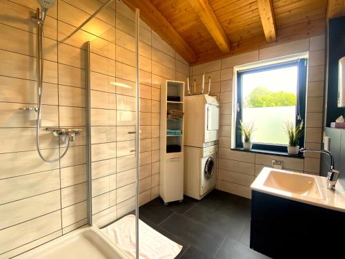 een badkamer met een douche, een wastafel en een koelkast bij Ferienwohnung am Weiher Kategorie 1 in Nideggen