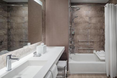 y baño con bañera, lavamanos y ducha. en AC Hotel by Marriott Fort Lauderdale Airport en Dania Beach
