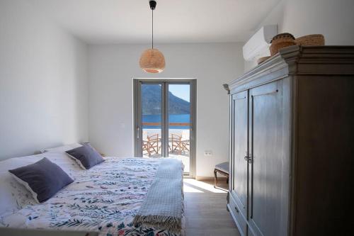 a bedroom with a bed and a large window at Villa Kalydna in Kalymnos