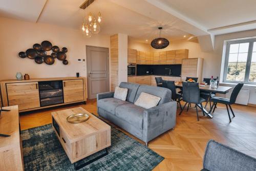 un salon avec un canapé et une table dans l'établissement Domaine Grand Piquecaillou - L'appartement Pomerol, à Saint-Maixant