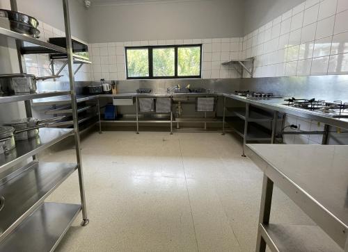 une grande cuisine avec des appareils et des comptoirs en acier inoxydable dans l'établissement Banana Backpackers, à Brisbane