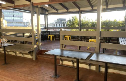a restaurant with benches and tables on a deck at Banana Backpackers in Brisbane