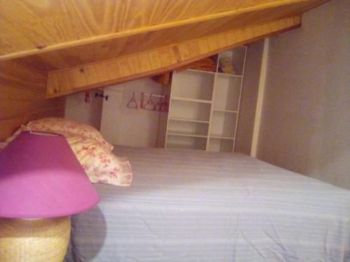 um quarto com um beliche e um candeeiro roxo em T1 ,ch mézanine,cuisine balcon em Langogne